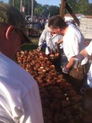 Brushing barbecue sauce on a giant mess of cooked chicken