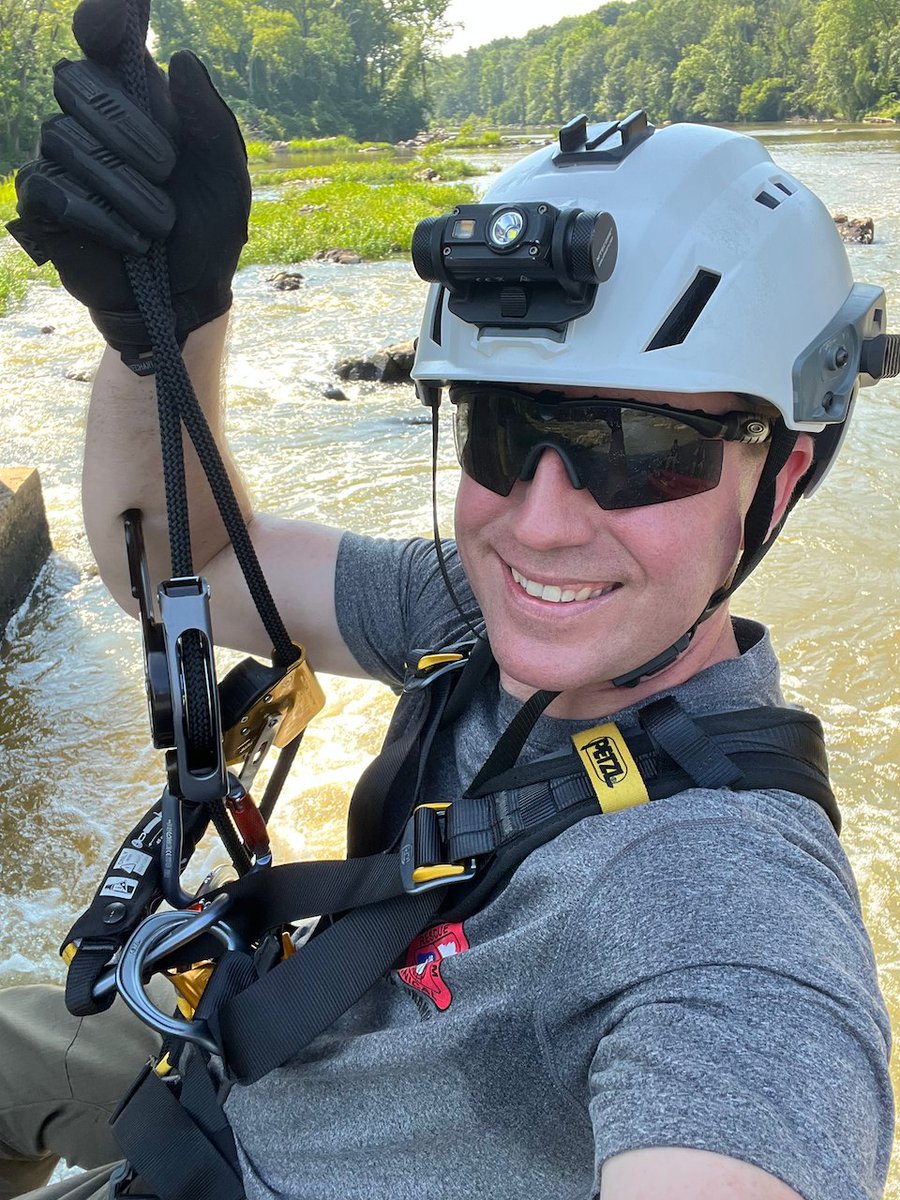 A selfie hanging from a bridge in rescue climbing gear
